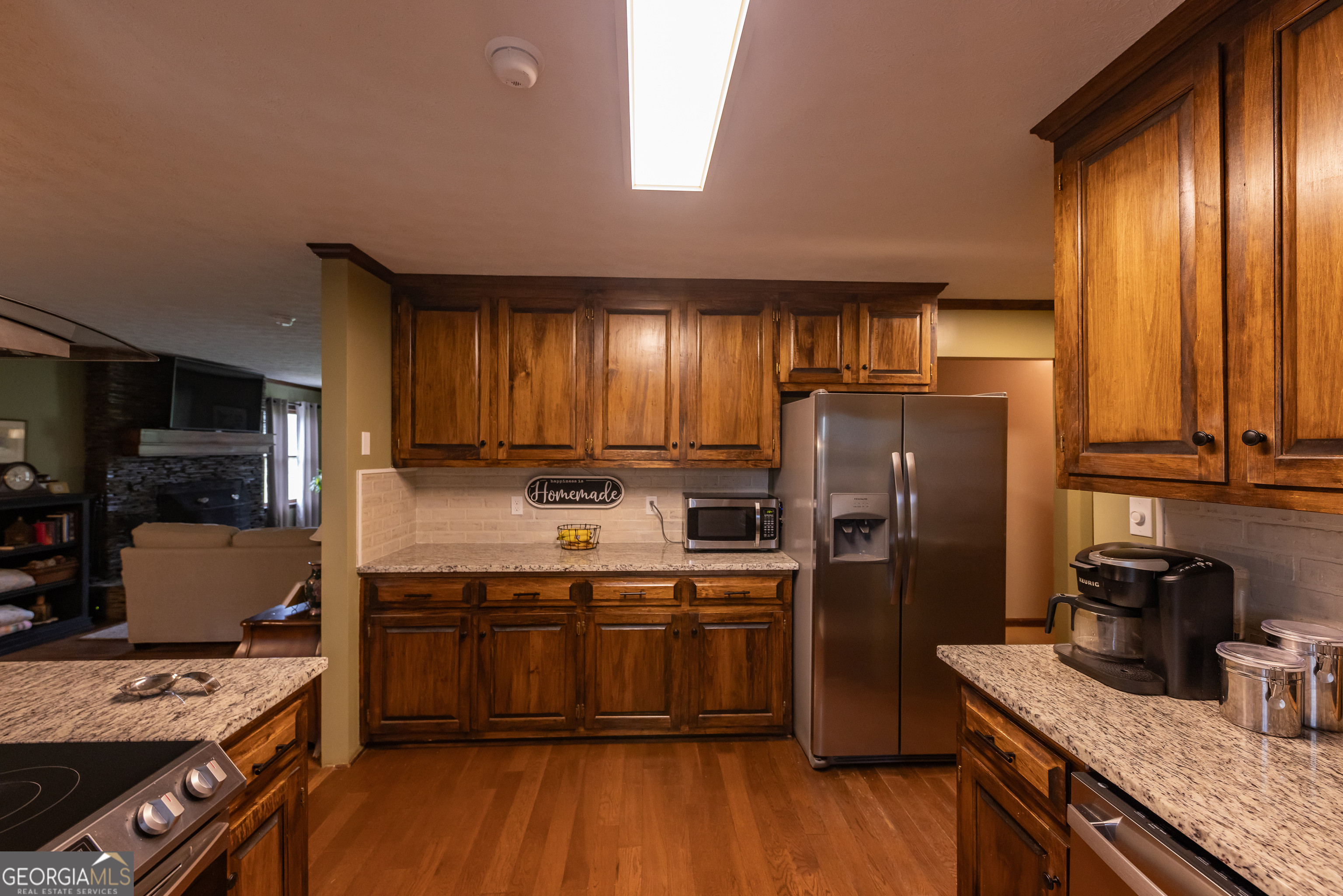 976 Windsweep Farm Road Thomaston, GA 30286 - Photo 13 of 98 a kitchen with stainless steel appliances granite countertop a refrigerator a stove a sink dishwasher and wooden cabinets with wooden floor