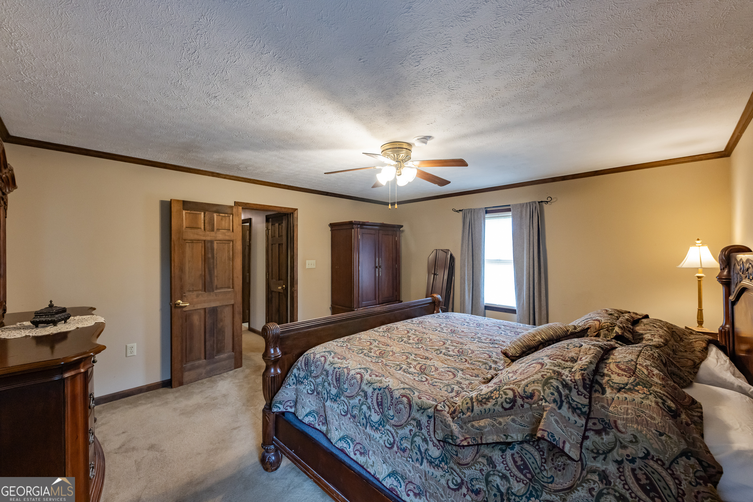 976 Windsweep Farm Road Thomaston, GA 30286 - Photo 15 of 98 a bedroom with a bed and a chandelier