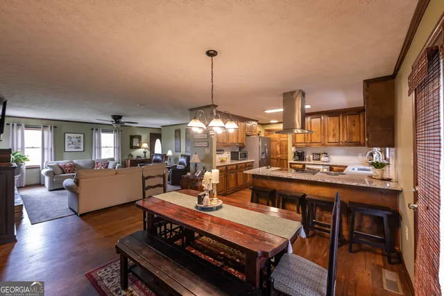 a kitchen with stainless steel appliances granite countertop a refrigerator a stove a sink dishwasher and wooden cabinets with wooden floor