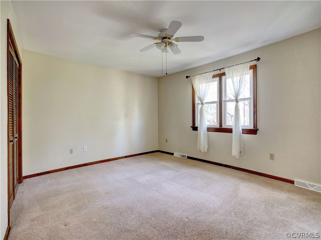 7400 Drexelbrook Road Chesterfield, VA 23832 - Photo 12 of 32 an empty room with a ceiling fan and windows