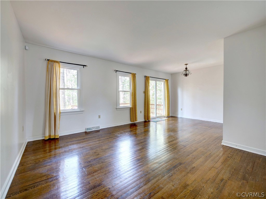 7400 Drexelbrook Road Chesterfield, VA 23832 - Photo 4 of 32 an empty room with wooden floor and windows with curtains
