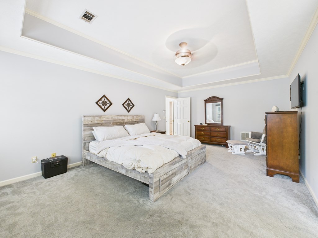 6390 Cape Cod Drive Columbus, GA 31904 - Photo 13 of 22 a spacious bedroom with a bed and a chandelier