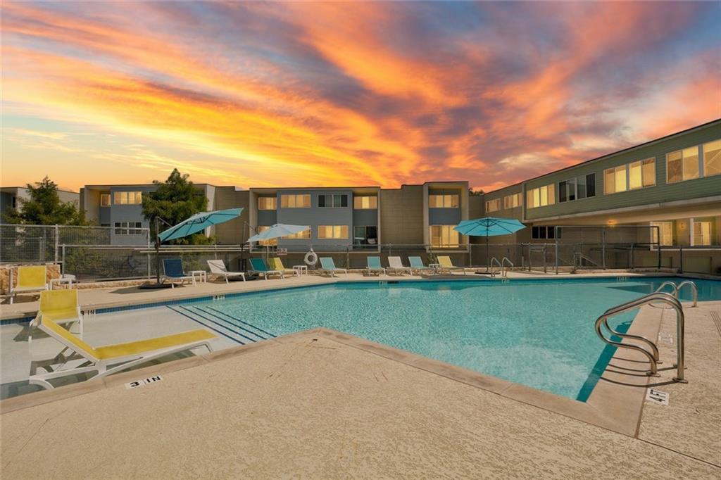 604 North Bluff Drive, Unit 101 Austin, TX 78745 - Photo 3 of 22 Pool at dusk featuring a community pool and a patio