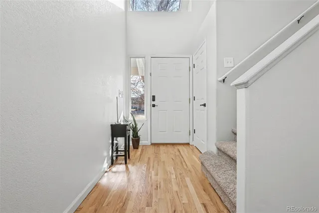 a view of a hallway with wooden floor and staircase