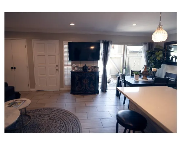 a living room with furniture a flat screen tv and a large window