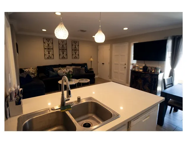 a kitchen with a sink and a stove top oven with wooden floor