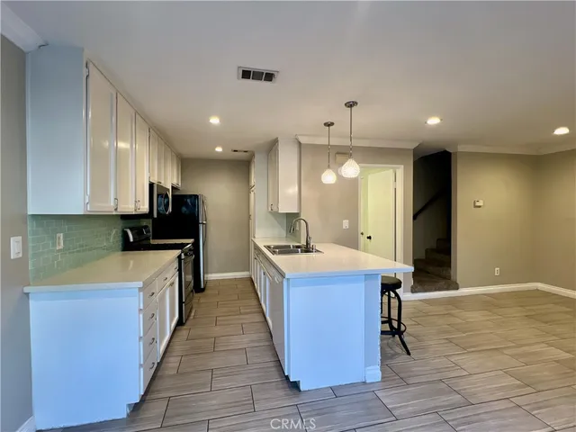 a kitchen with kitchen island granite countertop wooden cabinets and refrigerator