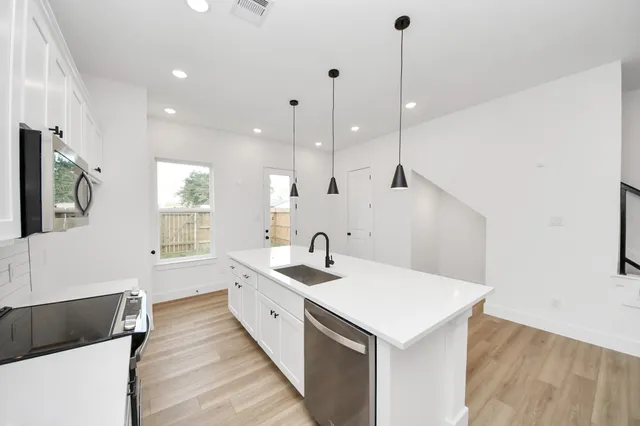 a kitchen with a sink a counter top space and appliances