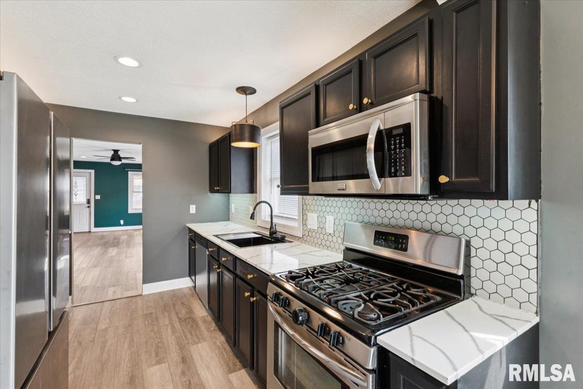 1911 23rd Street, Unit A Moline, IL 61265 - Photo 10 of 28 a kitchen with stainless steel appliances a stove a sink and a microwave