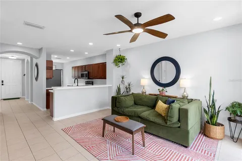 a living room with furniture and a view of kitchen