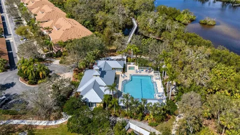 an aerial view of residential houses with outdoor space and lake view