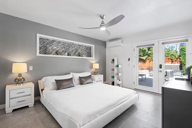 a bedroom with a white bed and wooden floor