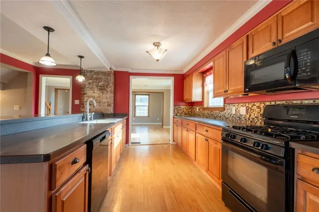 a kitchen with stainless steel appliances granite countertop a stove a sink and a microwave