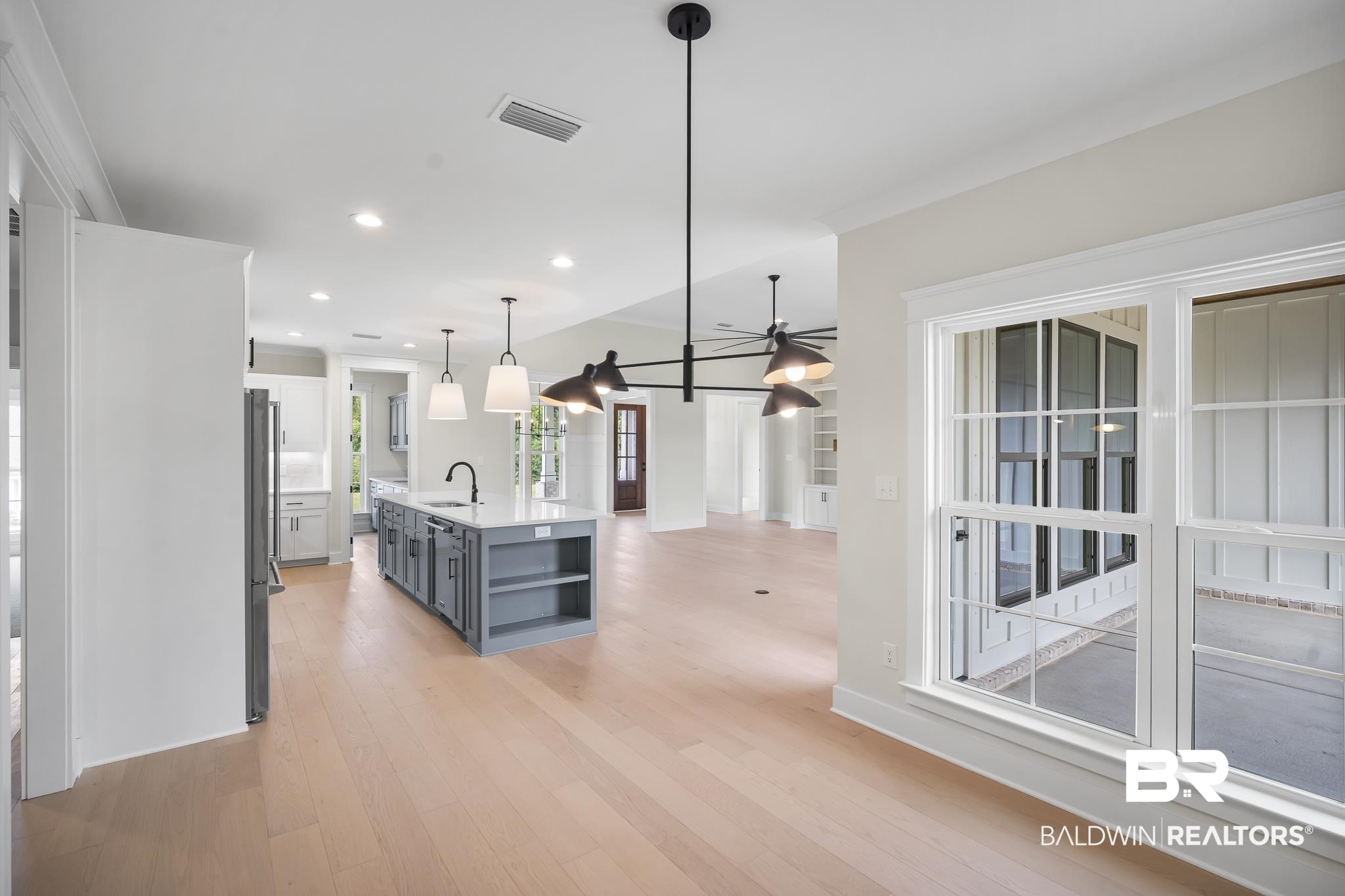 21826 Veranda Boulevard Fairhope, AL 36532 - Photo 13 of 42 Kitchen featuring open shelves, a center island with sink, recessed lighting, light wood-type flooring, and pendant lighting