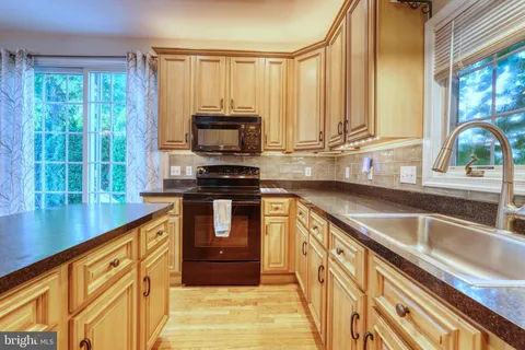 a kitchen with stainless steel appliances a sink window and cabinets