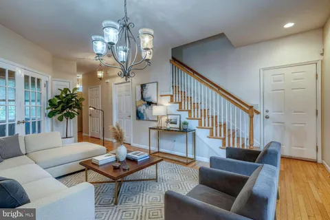 a living room with furniture a wooden floor and a chandelier