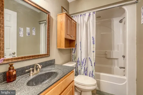 a bathroom with a granite countertop sink toilet and shower