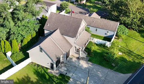 an aerial view of a house with a yard and a large tree