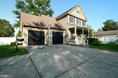 a view of a white house with a yard and plants