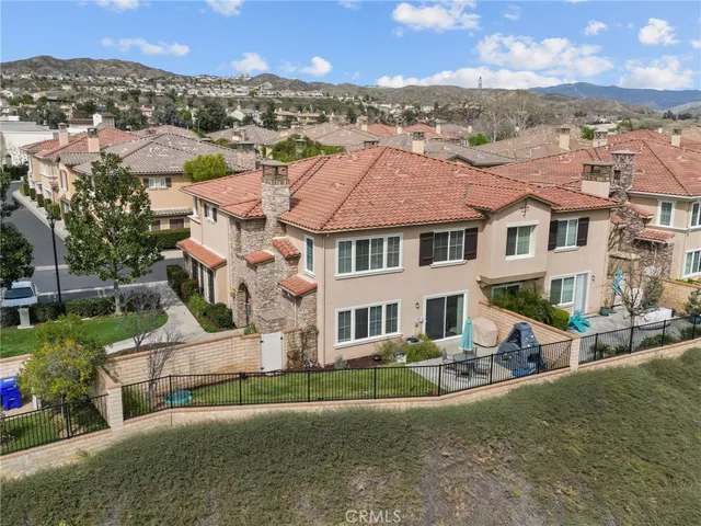 an aerial view of residential houses with outdoor space and trees