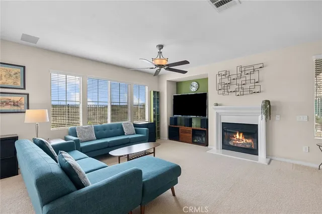 a living room with furniture a fireplace and a large window