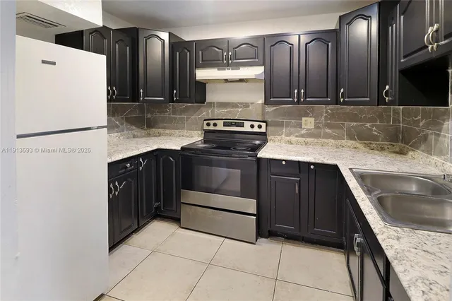 a kitchen with a stove a refrigerator and a sink