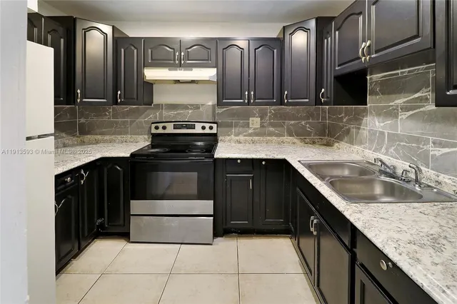 a kitchen with stainless steel appliances granite countertop a sink stove and cabinets