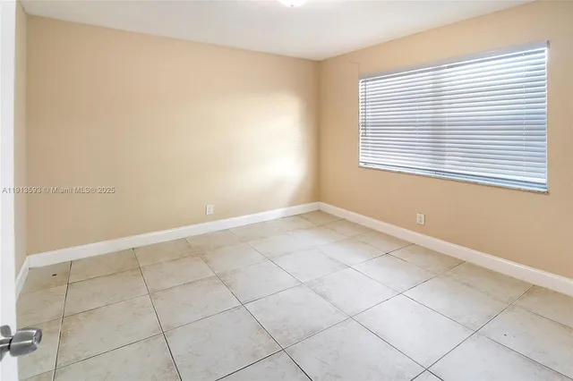 an empty room with a chandelier fan