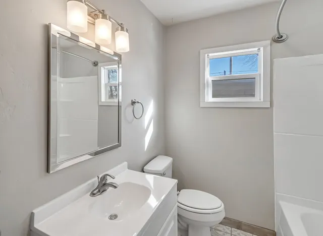 an empty room with a window and ceiling fan
