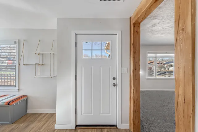 an empty room with windows and ceiling fan