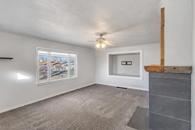 a big room with fireplace and a chandelier fan