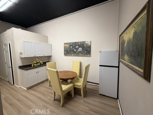 24609 Arch Street Newhall, CA 91321 - Photo 4 of 29 a kitchen with stainless steel appliances a refrigerator a stove a dining table and chairs