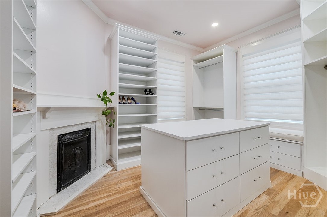 514 Maupas Avenue Savannah, GA 31401 - Photo 33 of 53 A walk-in closet like no other, with an original fireplace and mantel no less! Wonderful built-in island with drawer storage. The oak flooring runs under the cabinetry so the room could be converted back to the fourth bedroom.