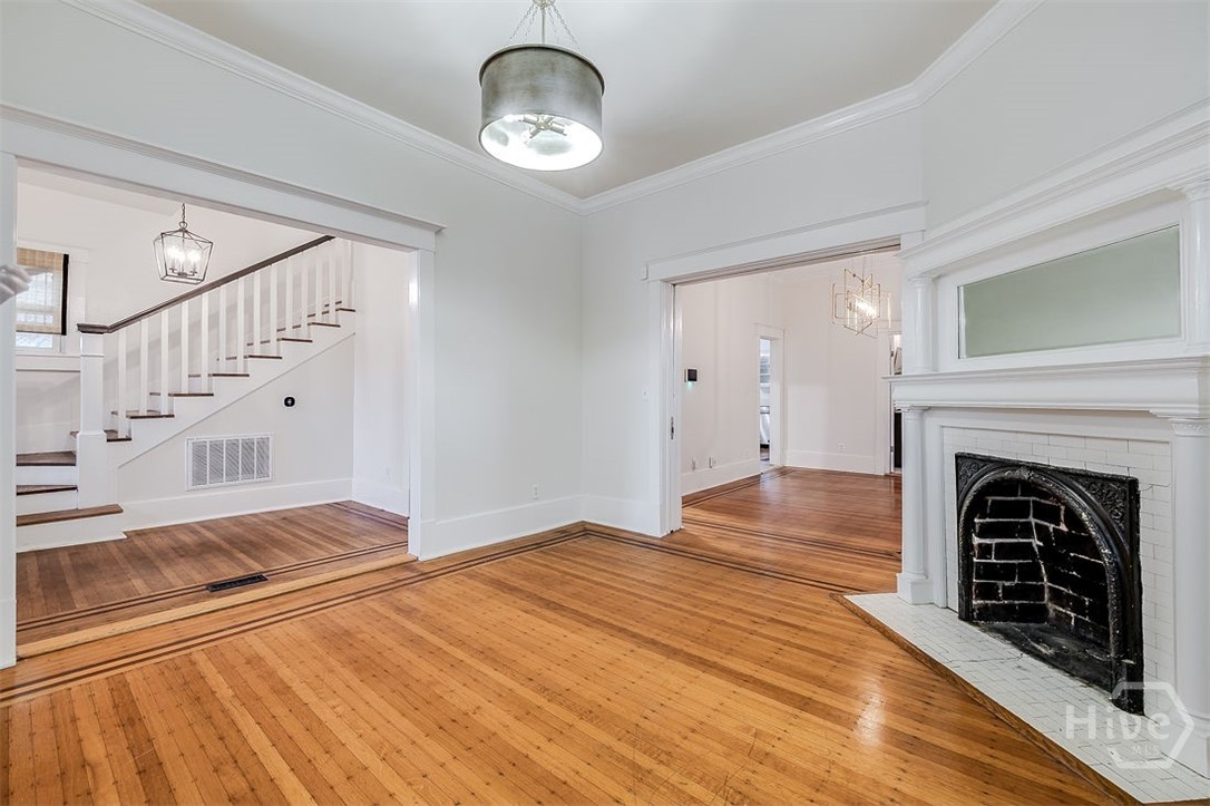 514 Maupas Avenue Savannah, GA 31401 - Photo 9 of 53 View of the front living room with its original fireplace and mantel, looking toward the entryway.