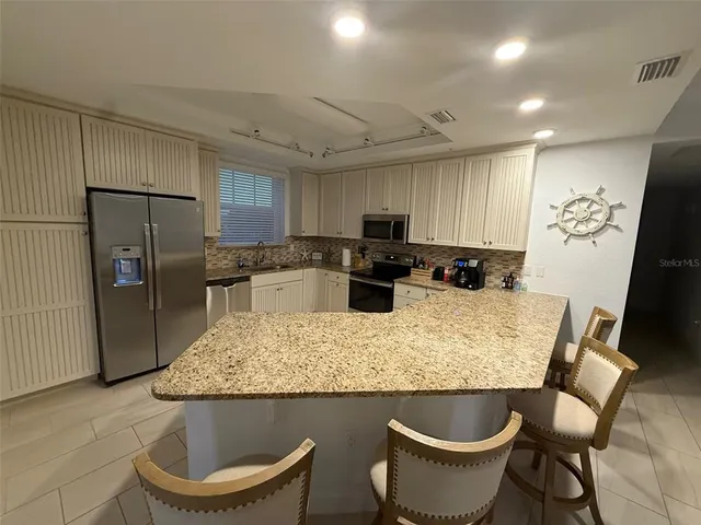 a kitchen with a table chairs refrigerator and microwave
