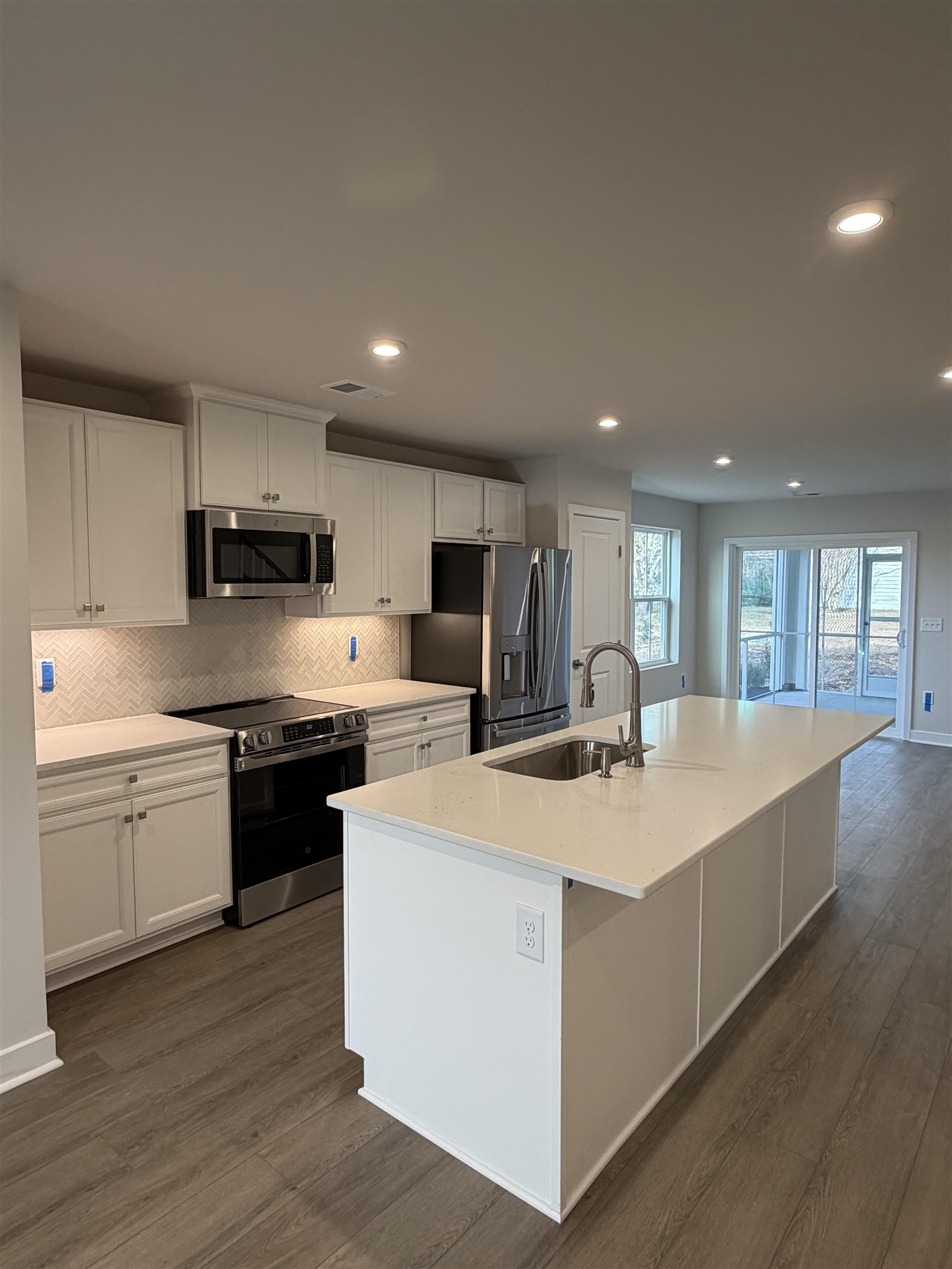 1311 Pleasant View Drive, Unit F North Myrtle Beach, SC 29582 - Photo 2 of 13 Kitchen with white cabinets, appliances with stainless steel finishes, a kitchen island with sink, dark wood finished floors, and recessed lighting