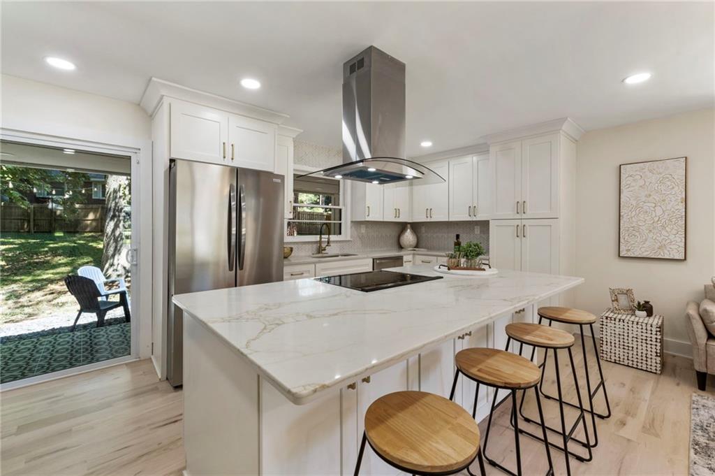 1690 Carter Road Decatur, GA 30032 - Photo 17 of 49 a kitchen with stainless steel appliances a table chairs refrigerator and wooden floor