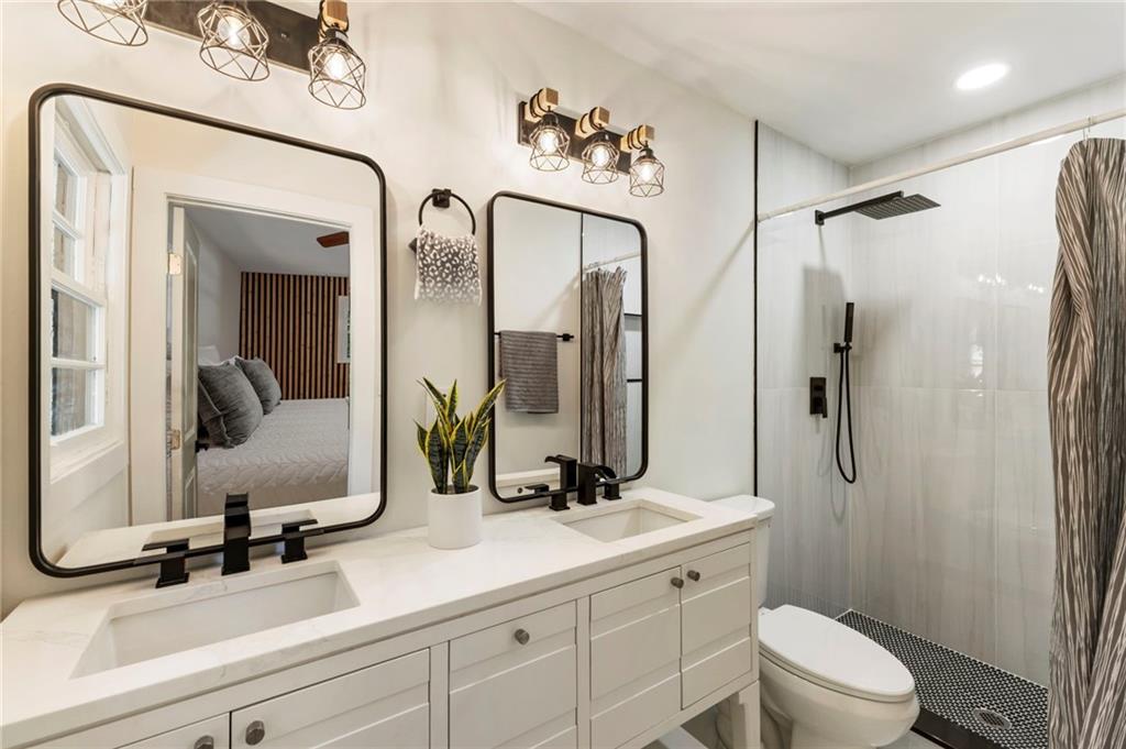 1690 Carter Road Decatur, GA 30032 - Photo 33 of 49 a bathroom with a double vanity sink mirror double and shower