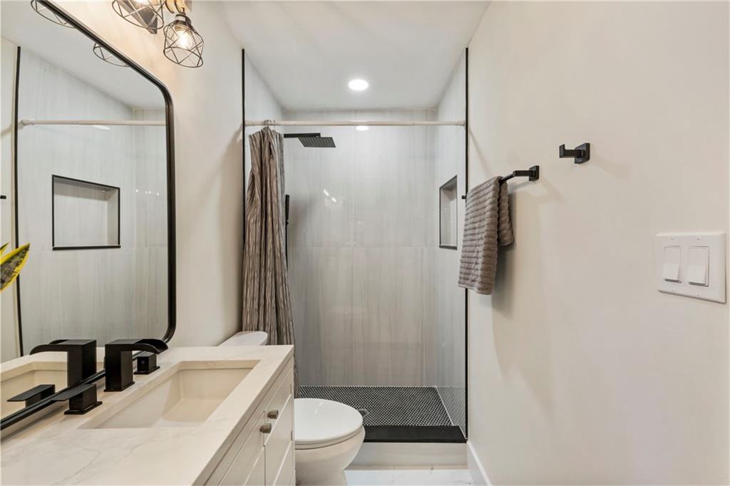 1690 Carter Road Decatur, GA 30032 - Photo 34 of 49 a bathroom with a sink a toilet a mirror and shower