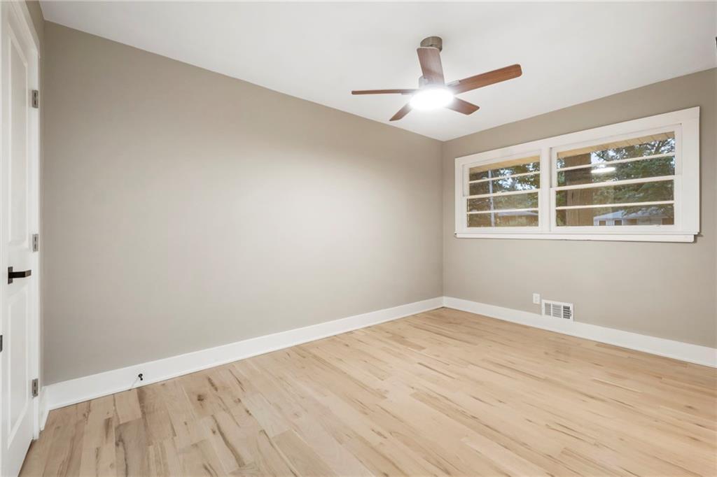 1690 Carter Road Decatur, GA 30032 - Photo 37 of 49 an empty room with wooden floor ceiling fan and window