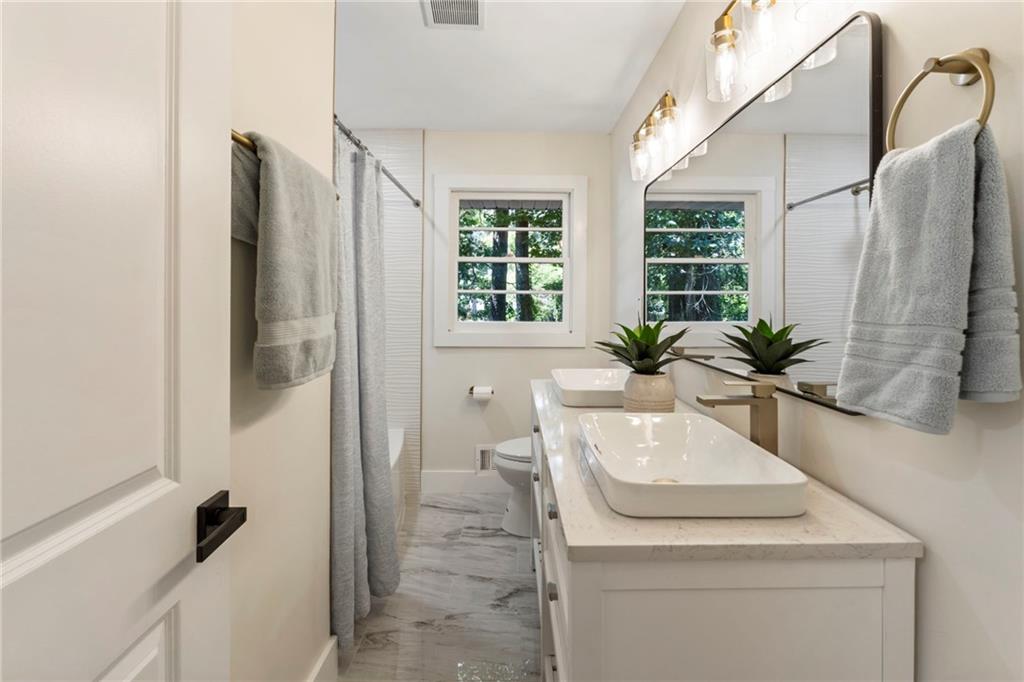 1690 Carter Road Decatur, GA 30032 - Photo 39 of 49 a bathroom with a sink a bathtub and a window