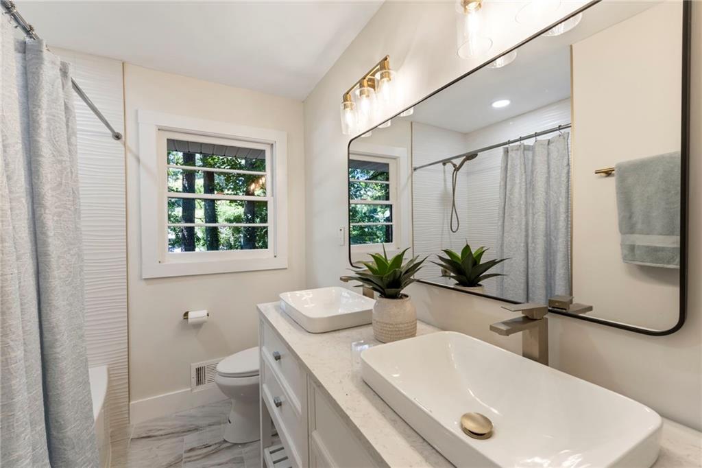 1690 Carter Road Decatur, GA 30032 - Photo 40 of 49 a bathroom with a sink a toilet a window and tub