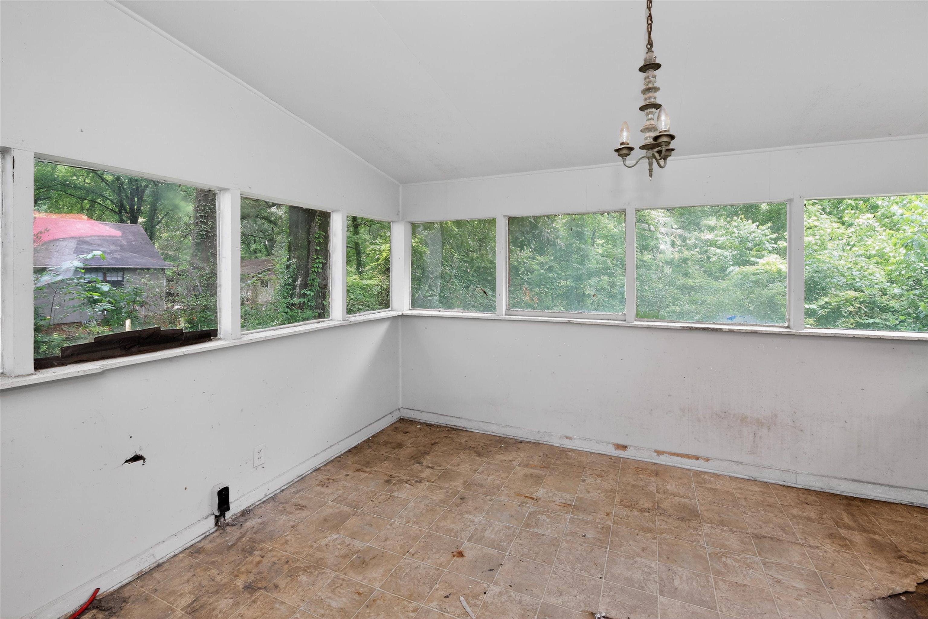 810 Hale Road Memphis, TN 38116 - Photo 29 of 30 Sunroom with multiple large windows, a sloped ceiling, and a central chandelier fixture