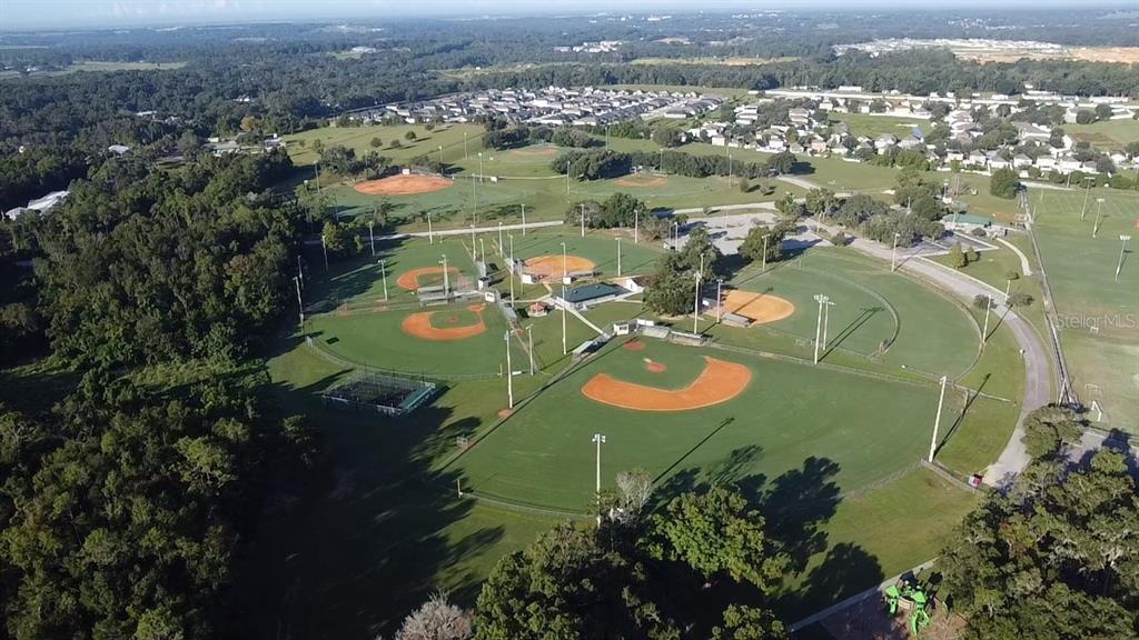 13322 Ogden Glade Road Dade City, FL 33525 - Photo 24 of 24 an aerial view of a house with a swimming pool yard and mountain view in back