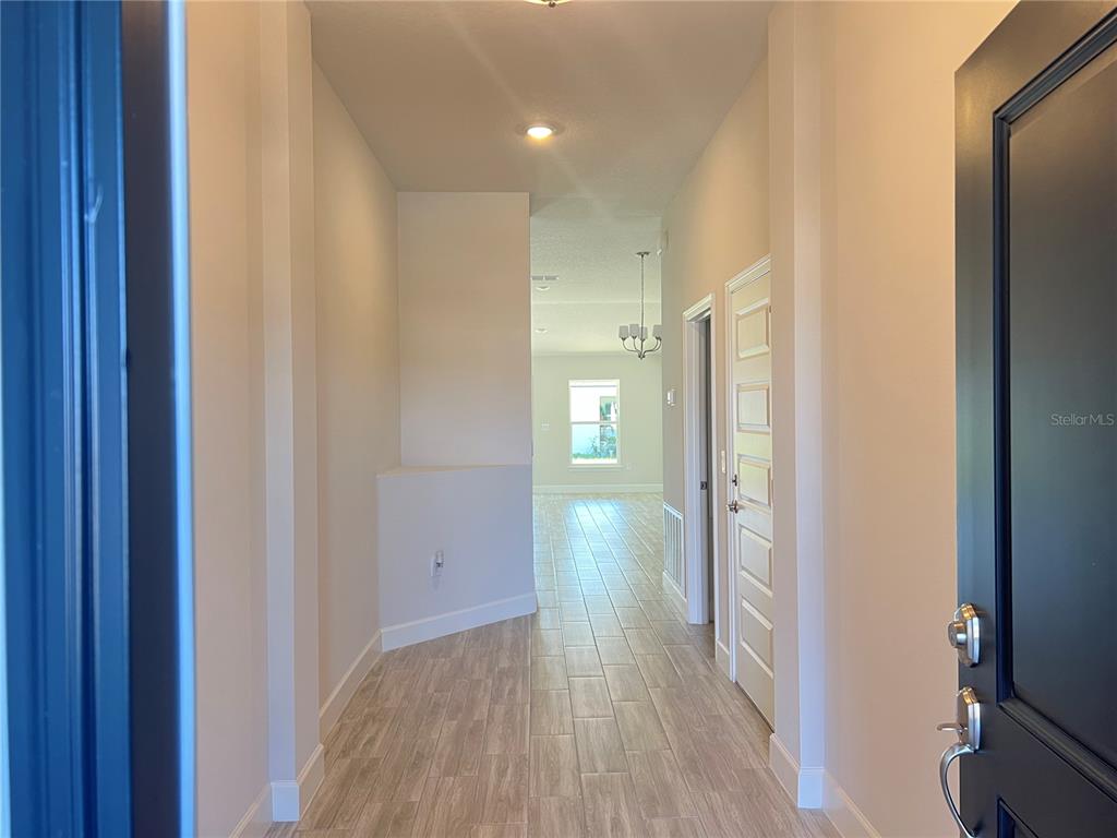 13322 Ogden Glade Road Dade City, FL 33525 - Photo 3 of 24 a view of hallway with wooden floor
