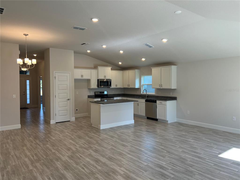 13322 Ogden Glade Road Dade City, FL 33525 - Photo 5 of 24 a view of kitchen with granite countertop refrigerator and white cabinets