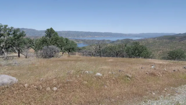 a view of a dry yard with mountains in the background