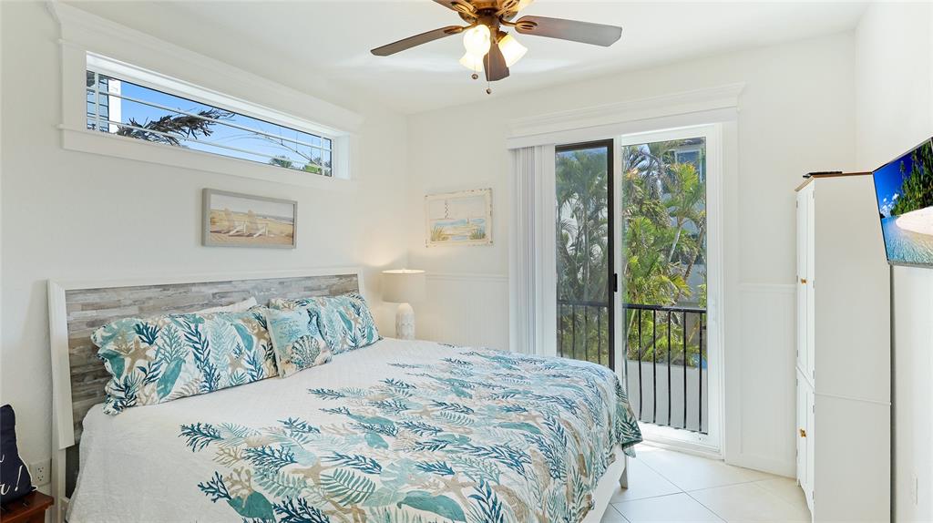 4101 4th Avenue Holmes Beach, FL 34217 - Photo 17 of 60 a bedroom with a large bed and a chandelier