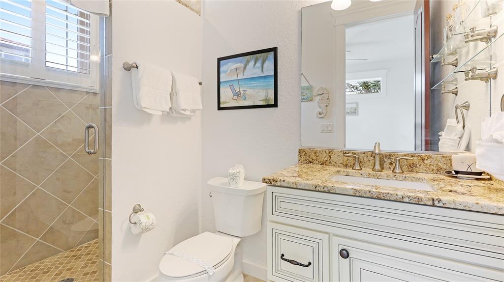 4101 4th Avenue Holmes Beach, FL 34217 - Photo 20 of 60 a bathroom with a granite countertop toilet sink and mirror