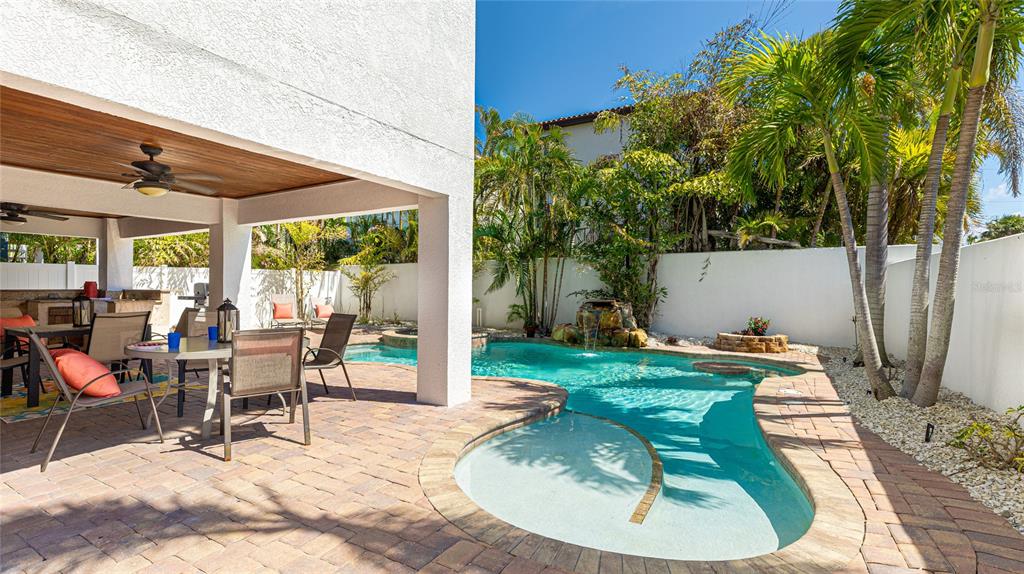 4101 4th Avenue Holmes Beach, FL 34217 - Photo 42 of 60 a view of a patio with table and chairs potted plants and large tree